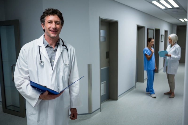 Doctor holding medical report in hospital corridor