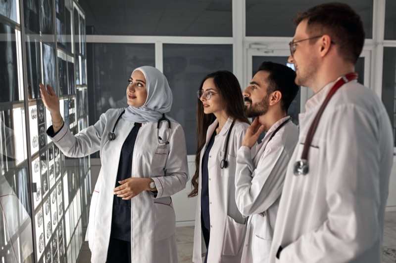 Doctors discussing diagnosis and reviewing x-rays together
